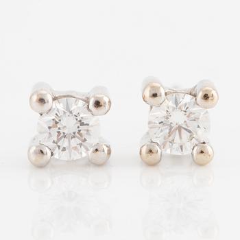 A pair of earrings in 18K white gold set with two round brilliant-cut diamonds.