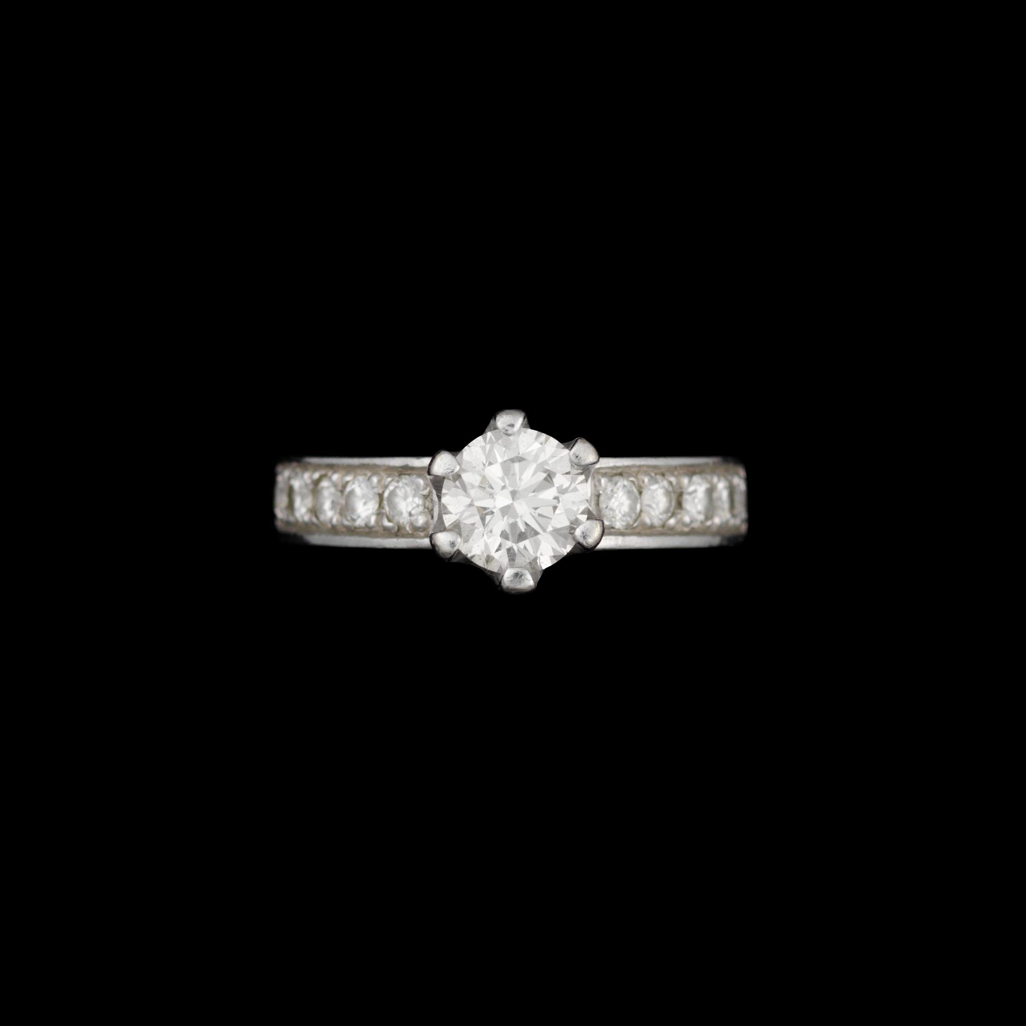 RING, 14K vitguld, briljantslipad diamant ca 0,80 ct, sidostenar tot. ca 0,20 ct. Vikt 5,9 g.