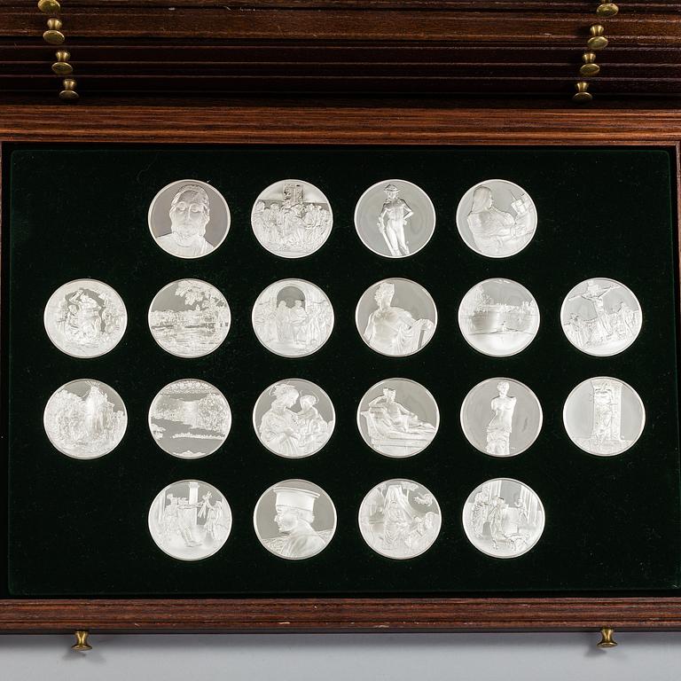 100 sterling silver coins in a wooden cabinet by Franklin Mint.