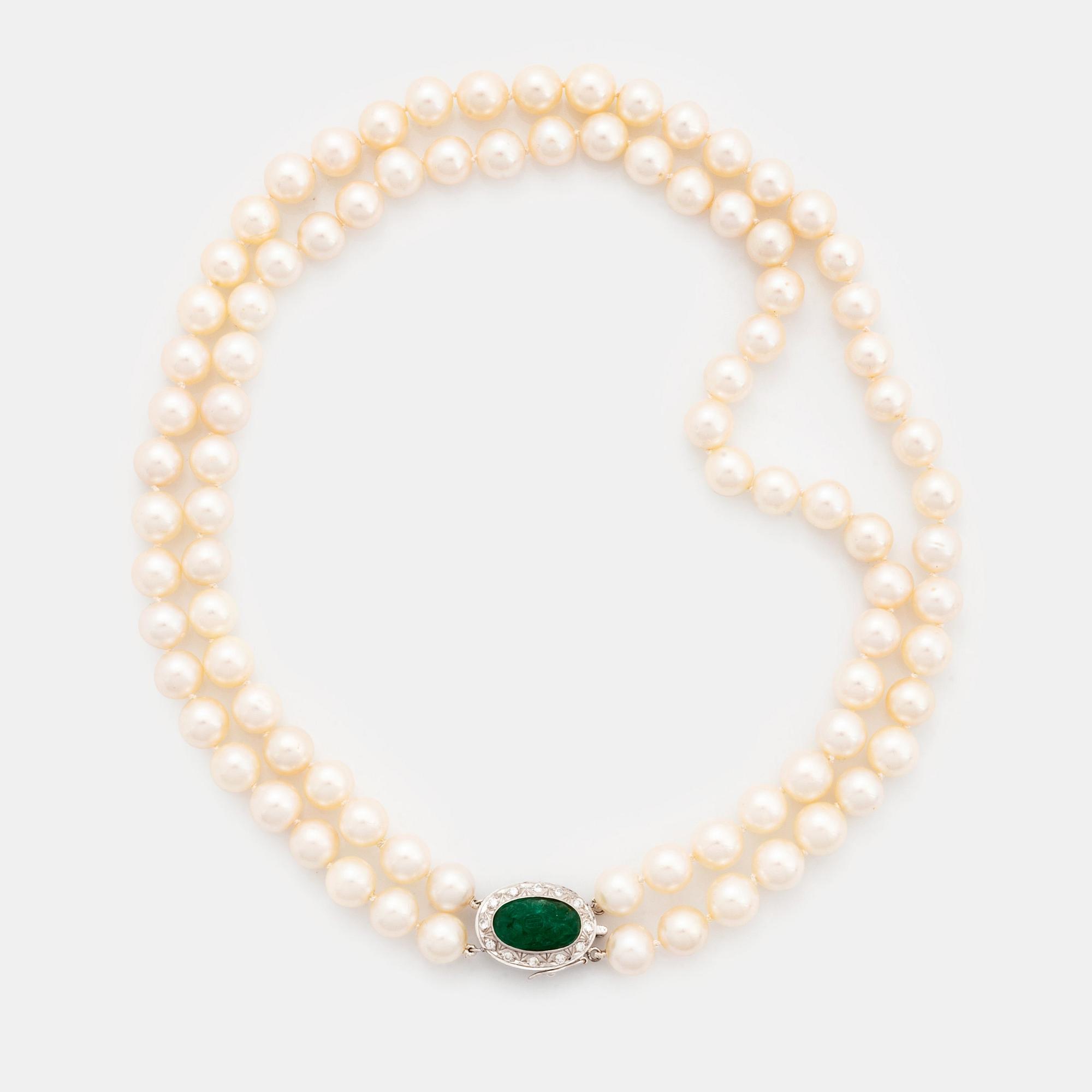 A two strand cultured pearl necklace with an 18K white gold and emerald clasp.