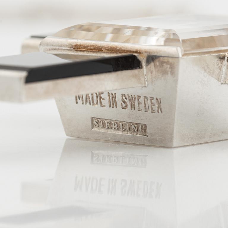 Wiwen Nilsson, hängsmycke i form av ett kors i sterlingsilver med fasettslipad bergkristall och onyx, Lund 1939.