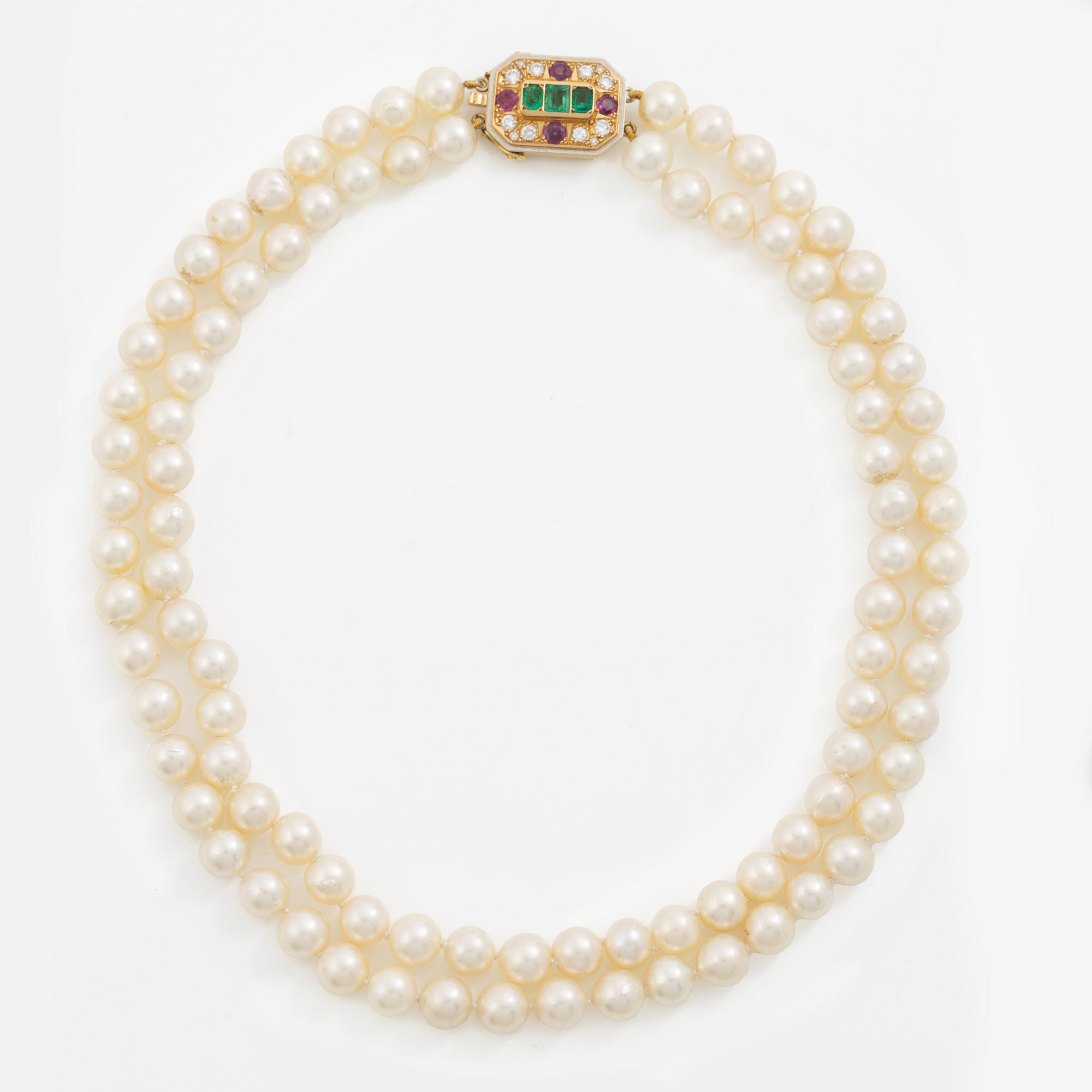 Pearl necklace, two-stranded, with a clasp by Seblings in 18K gold set with emeralds, rubies, and brilliant-cut diamonds.