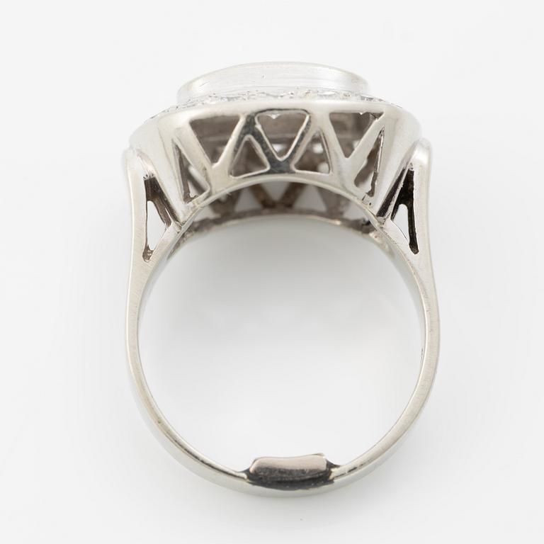 Oval-shaped 18K white gold ring with a brilliant-cut diamond and octagonal-cut diamonds.