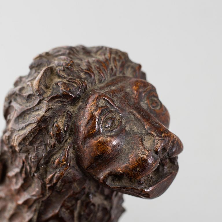 A 17TH CENTURY CARVED WOOD FIGURE OF A LION.