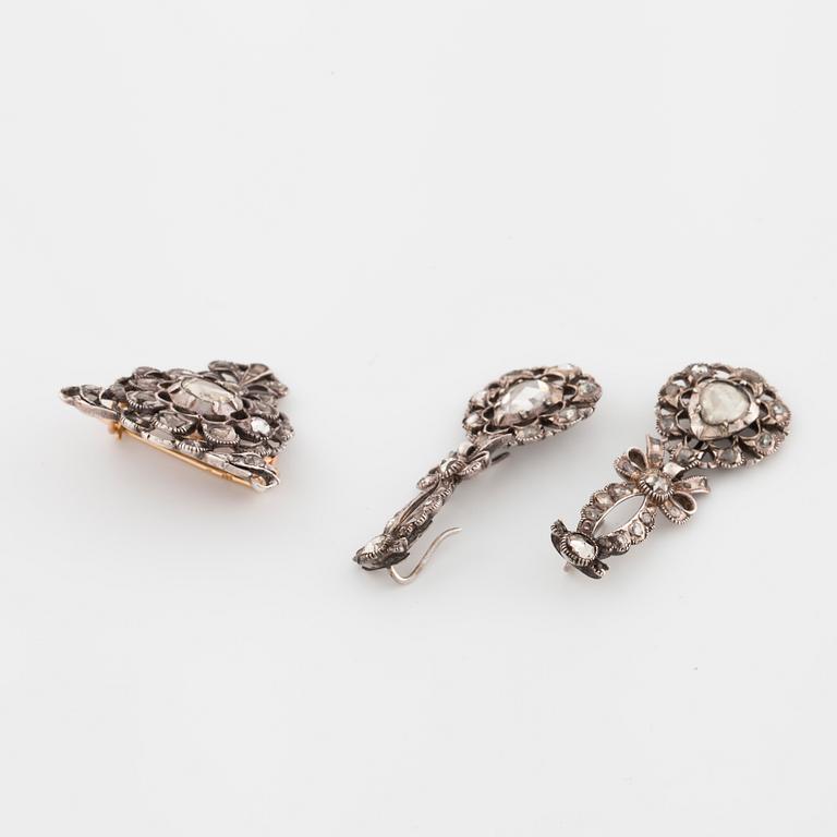 A pair of earrings and a brooch set with rose cut diamonds.