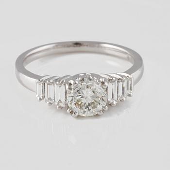 RING, 18K vitguld med briljantslipad diamant ca 1.01 ct samt baguetteslipade diamanter ca 0.29 ct. Vikt 4,0 gram.