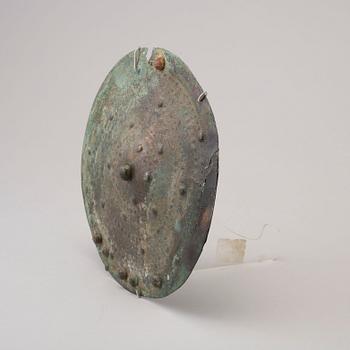 Three 20th century stone objects, with one bronze shield.