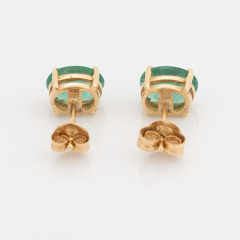 Gold and oval emerald earrings.