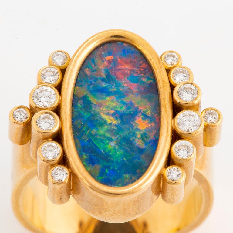 An 18K gold and opal ring set with round brilliant-cut diamonds.