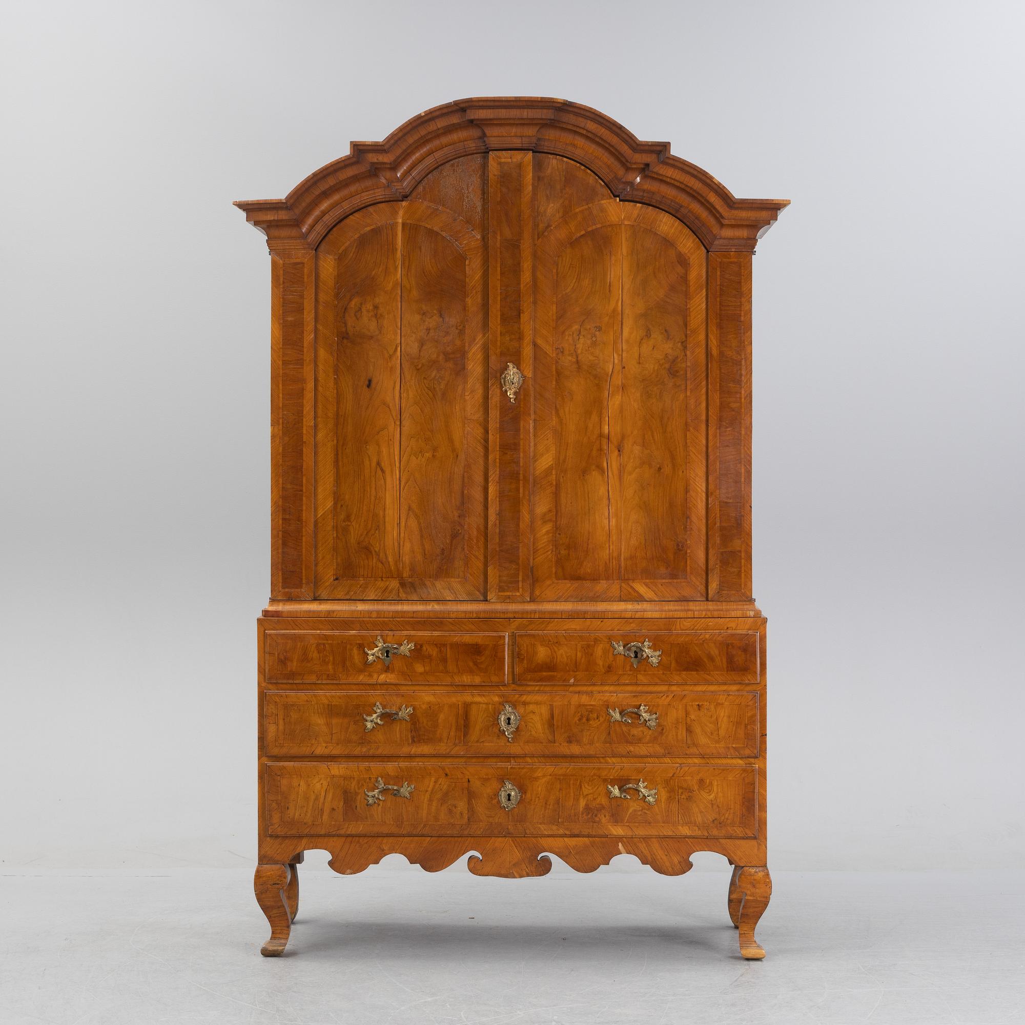 A walnut-veneered rococo cabinet in the manner of C. Linning, later part of the 18th Century.