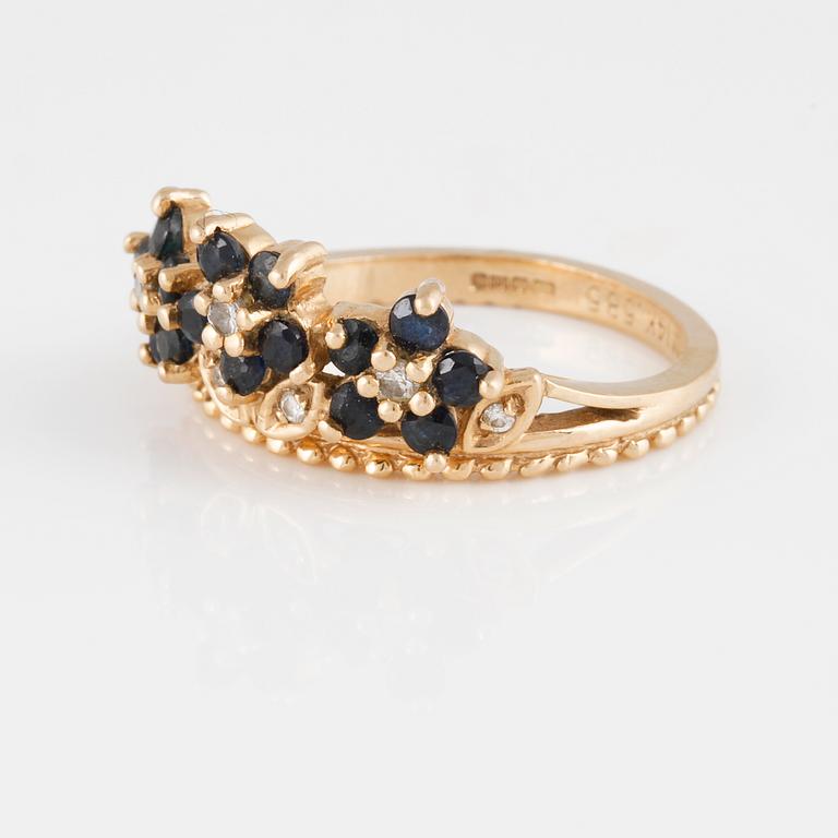 RING, 14K guld med sju briljantslipade diamanter samt femton blå safirer. Vikt 4,5 gram.