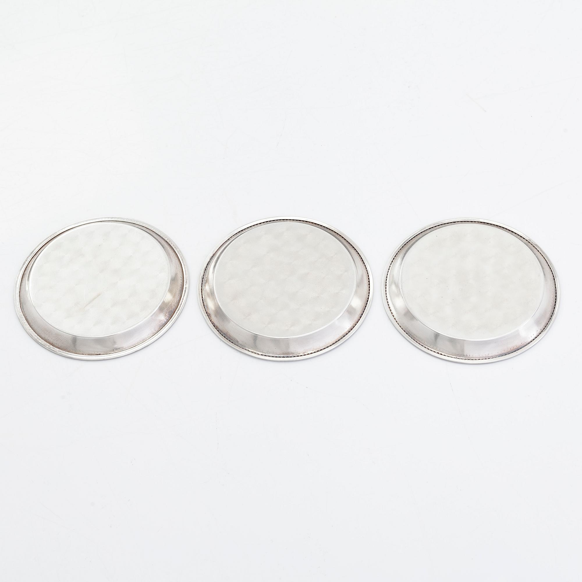 Coasters, 12 st, silver, Finland 1948-50 och coasters för vinflaska, 2 st, försilvrade, England.