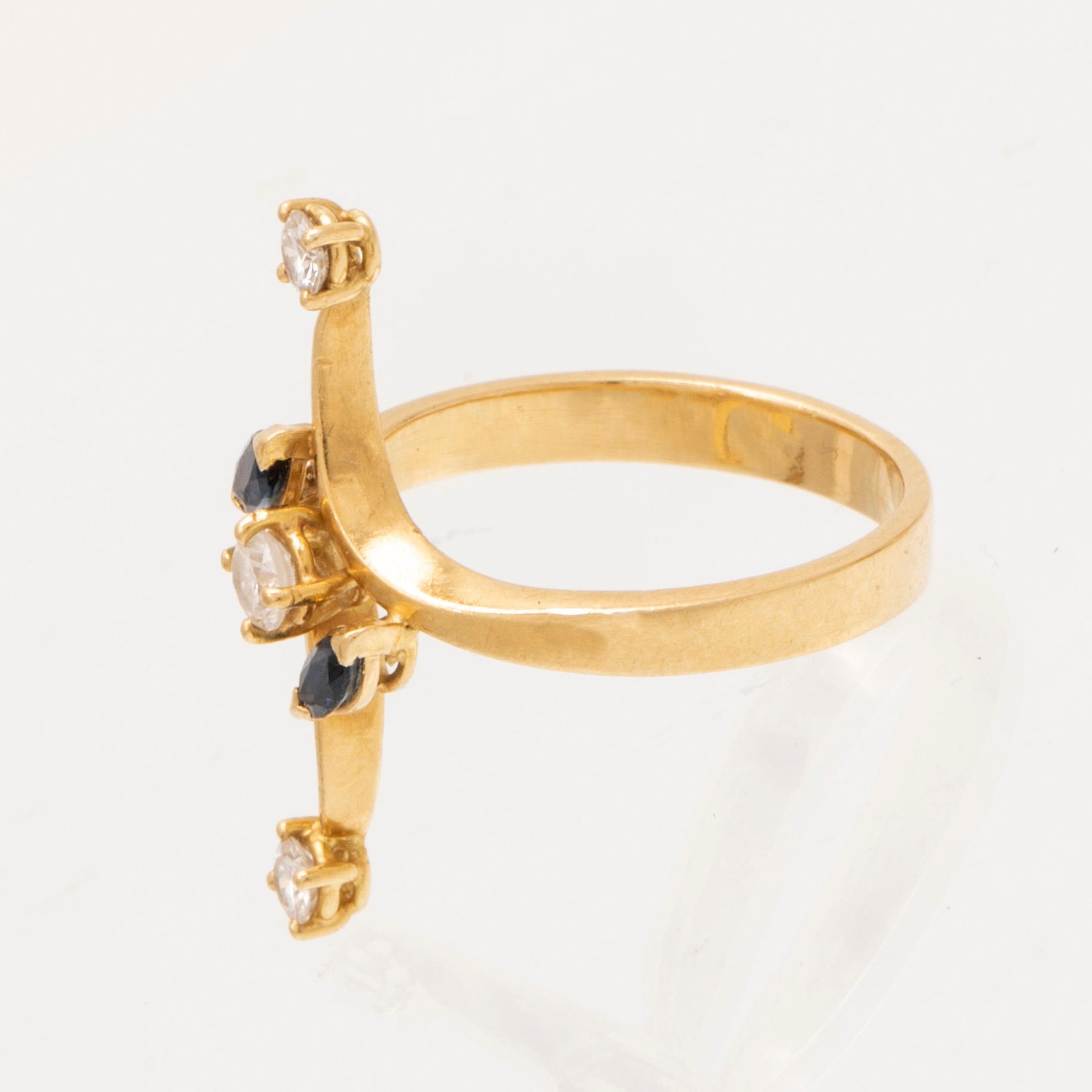 An 18K gold ring with marquise cut sapphires and round brilliant cut diamonds.
