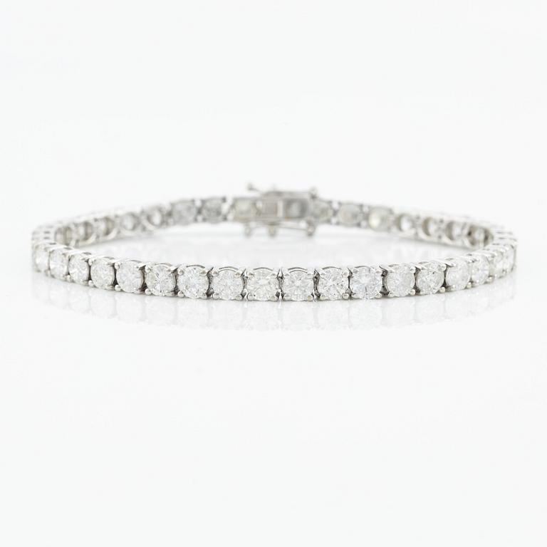 An 18K gold tennis bracelet with round brilliant-cut diamonds.