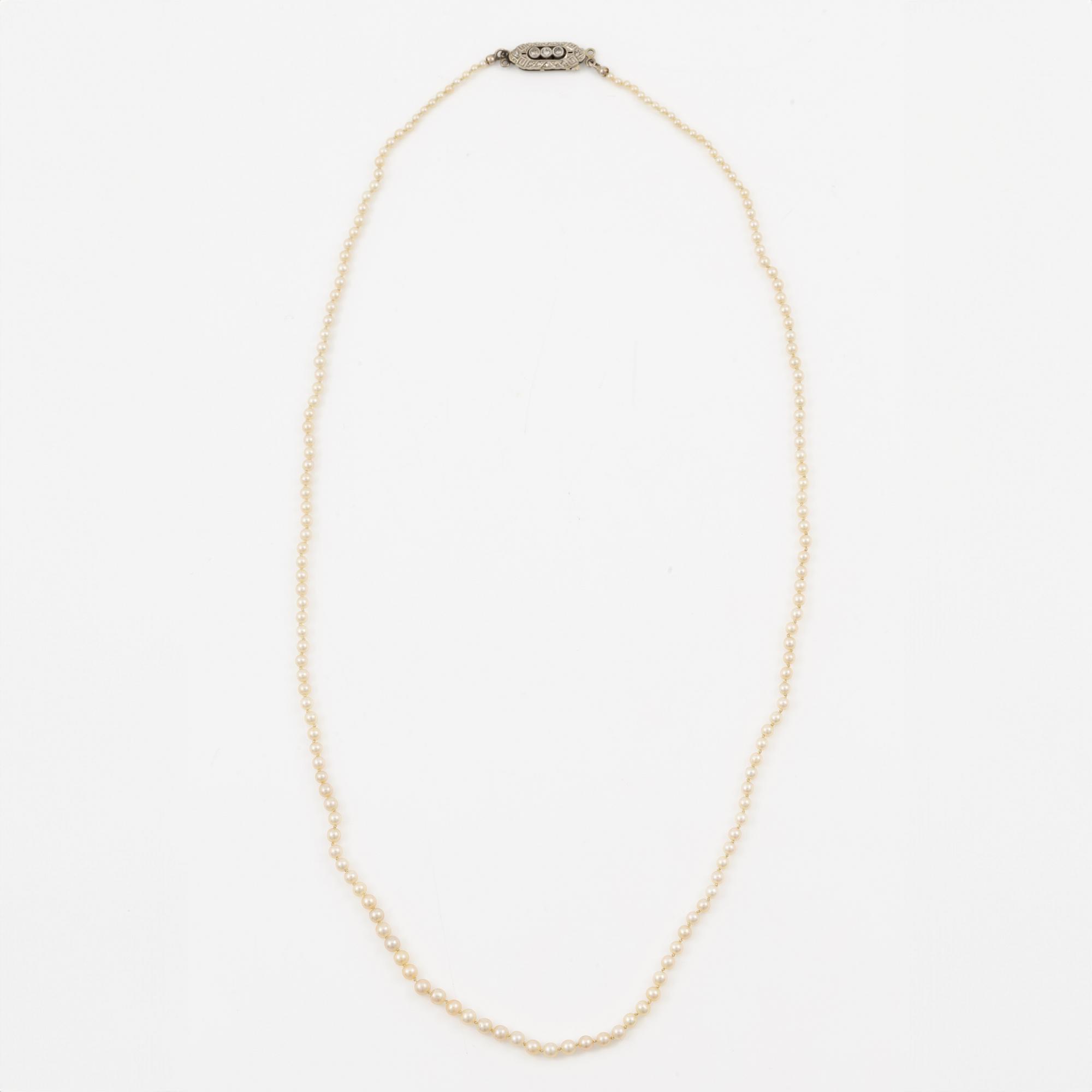 Pearl necklace, graduated pearls, clasp in 18K white gold with small diamonds.