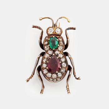 397. An antique 18K gold beetle brooch set with a faceted emerald and a garnet.