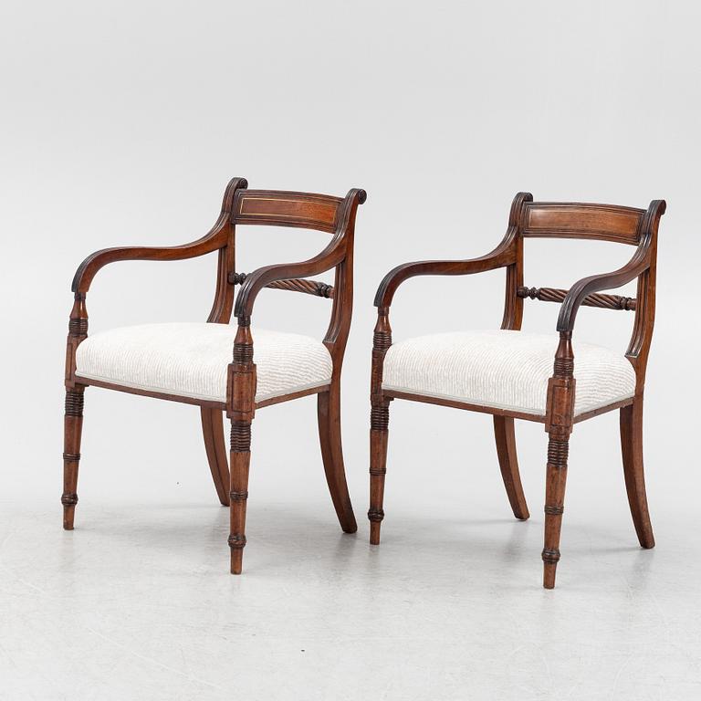 A set of 10 mahogany chairs and 2 armchairs, Regency style, from around the year 1900.