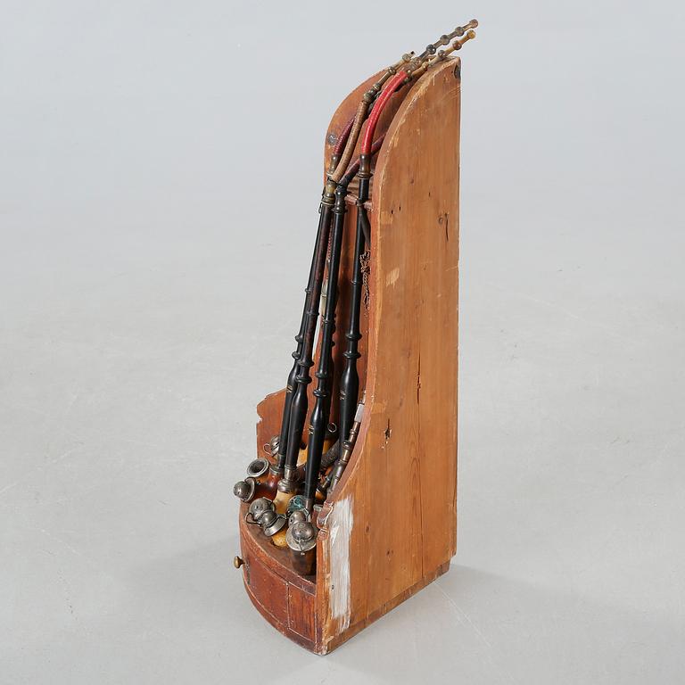 A 19th century pipe-rack with ten pipes and accessories.