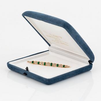 An 18K gold brooch set with step-cut emeralds and round brilliant-cut diamonds.