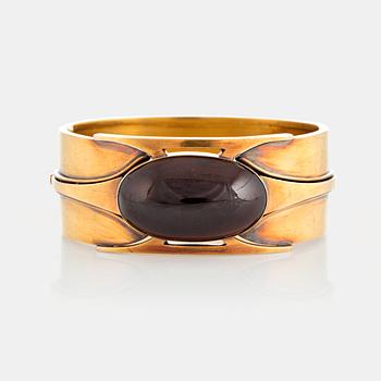 992. A 14K gold bangle set with a cabochon-cut garnet.