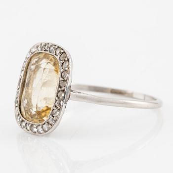 A ring in 18K white gold set with a yellow faceted tourmaline and rose-cut diamonds.