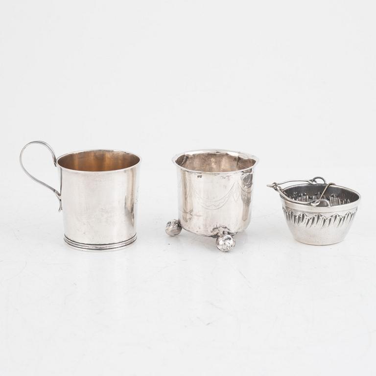 A silver beaker, a cup, a tea strainer and a sugar spoon, including Jacob Richard Bergh, Gävle 1845.