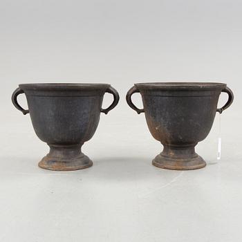 A pair of cast iron urns from the first half of the 1900s.