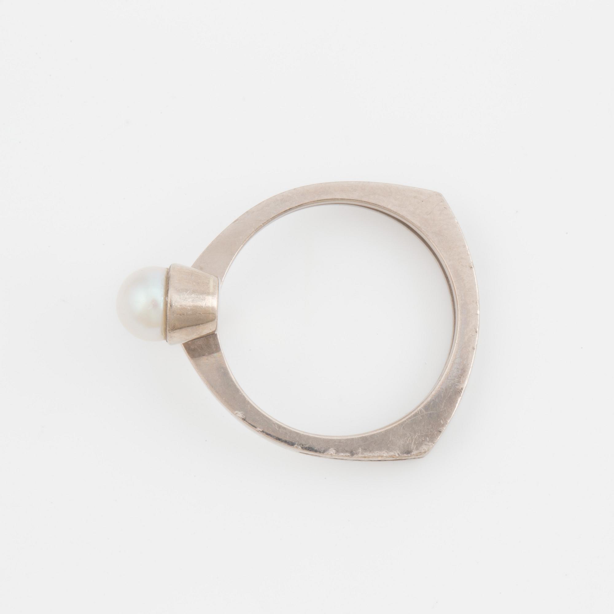 A ring set with a cultured pearl and a synthetic ruby.