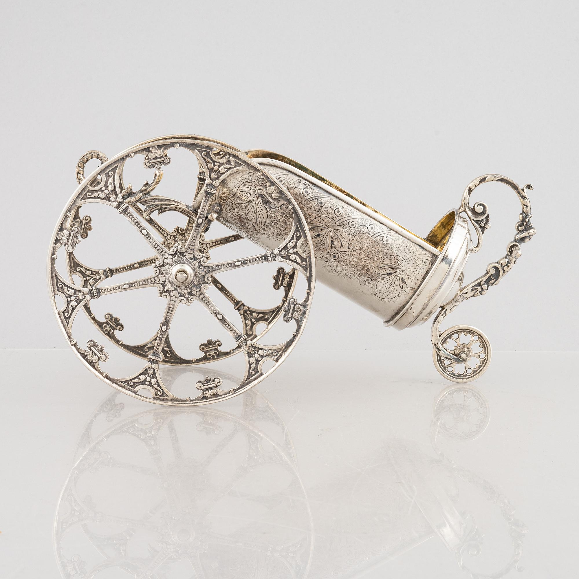 A silver bottle holder with wheels, 20th Century.