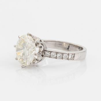 An 18K white gold ring set with a round brilliant-cut diamond.