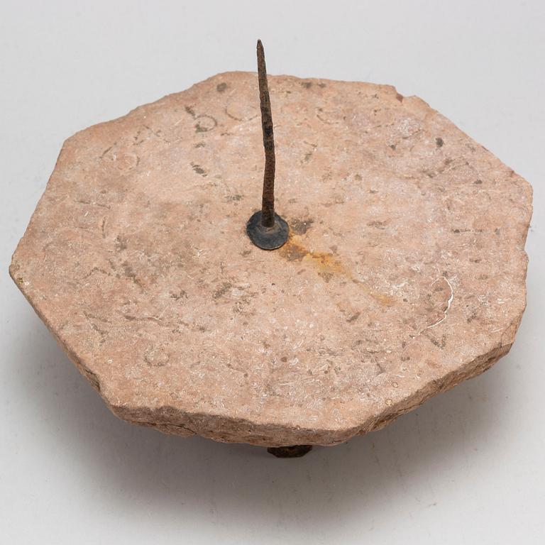 A limestone and iron sundial dated 1732.
