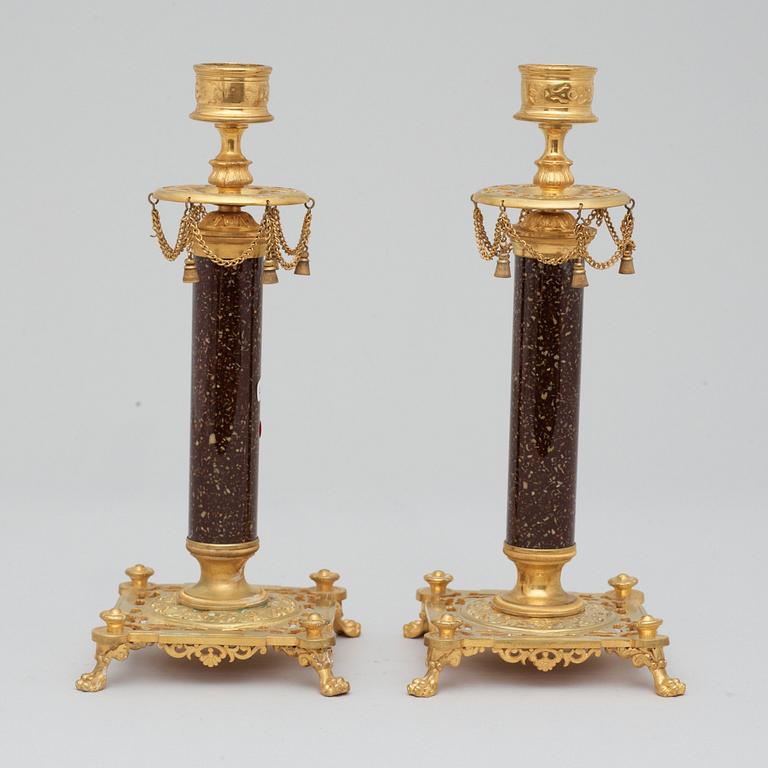 A pair of Swedish late 19th century brass and porphyry-imitation glass candlesticks.
