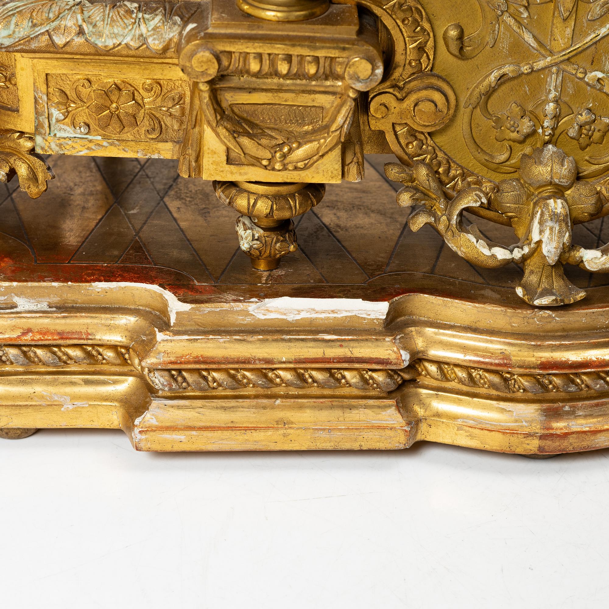A mantle clock and a pair of candelabra, Louis XVI style, ca 1900.