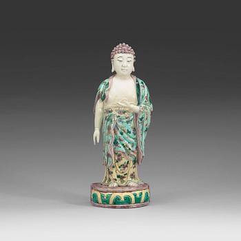 1653. A famille verte figure of a standing Buddha, Qing dynasty, 19th Century.