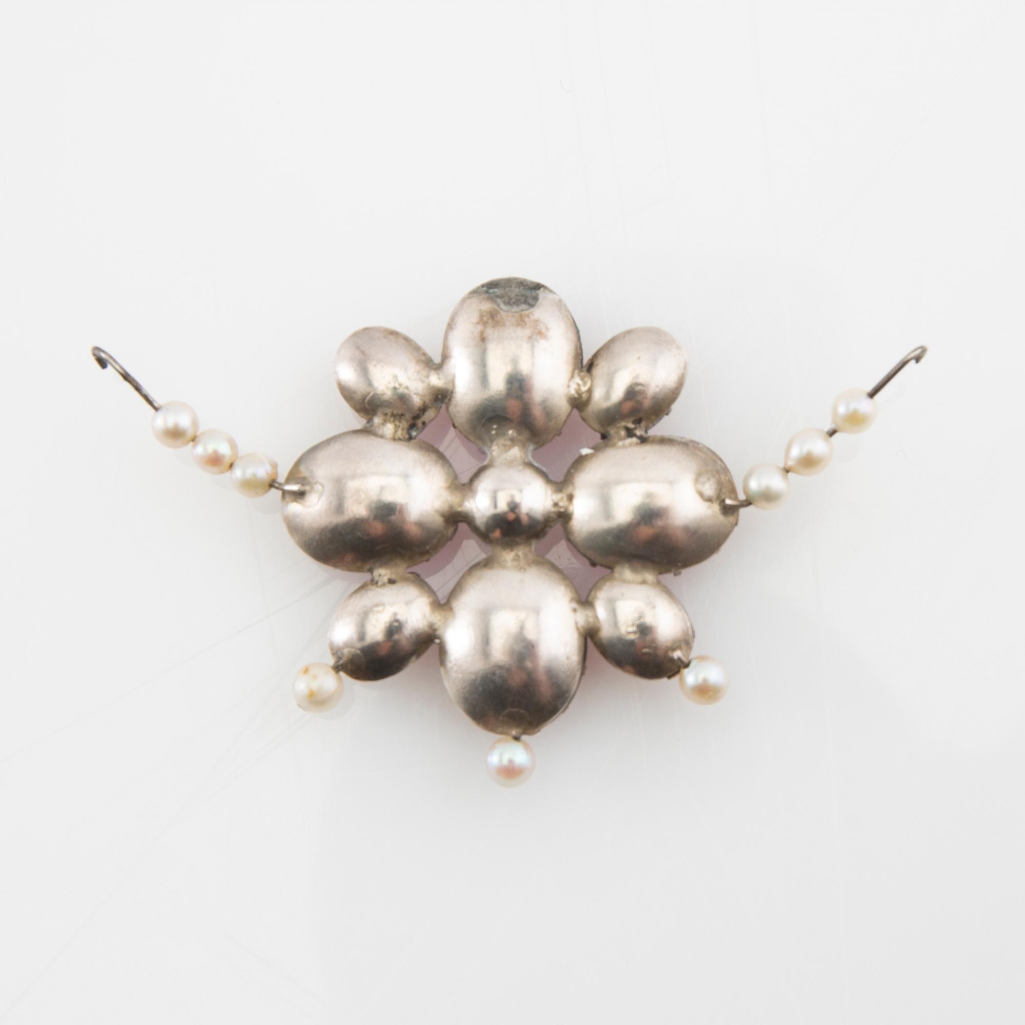 Tiara av silver med odlade pärlor och rosa fasetterat glas, ring av silver med syntetisk rosa safir, Hässleholm 1964.