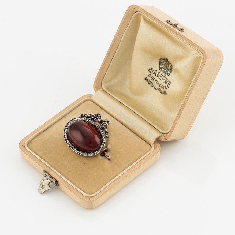 En brosch guld och silver med en cabochonslipad granat och rosenslipade diamanter, Fabergé.