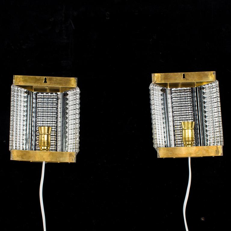 A pair of glass and brass wall lights by Wiktor Berndt for Swedish Crystal, 1970's.