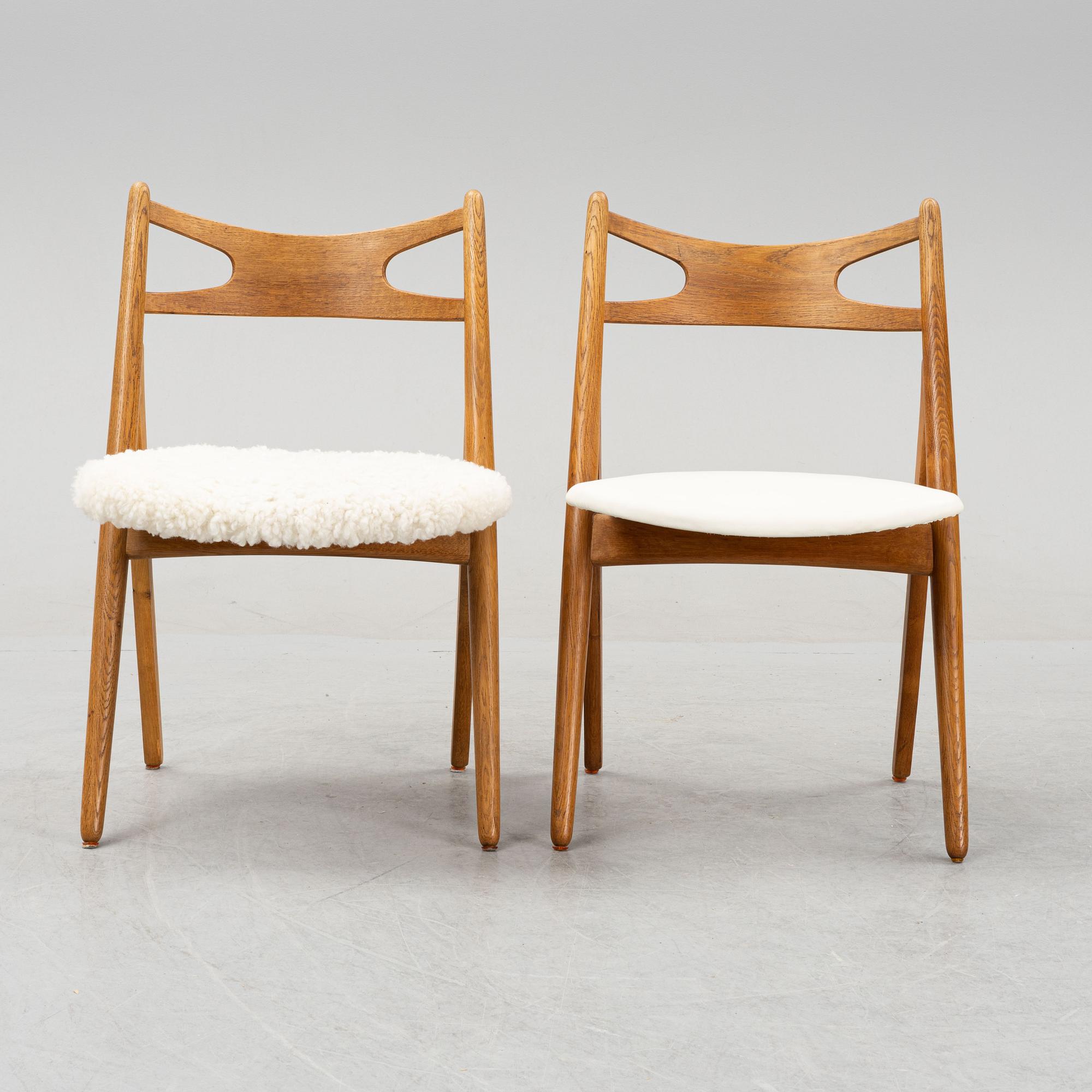 A set of six model CH 29 oak chairs by Hans J Wegner, two with leather upholstery and four with sheepskin.