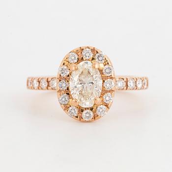 RING, 18K roséguld med 1 ovalslipad diamant samt runda briljantslipade diamanter.