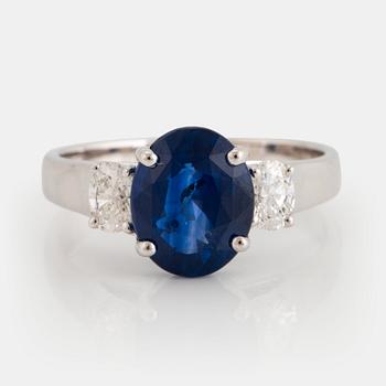 963. An 18K white gold ring set with an oval faceted sapphire and oval brilliant-cut diamonds.