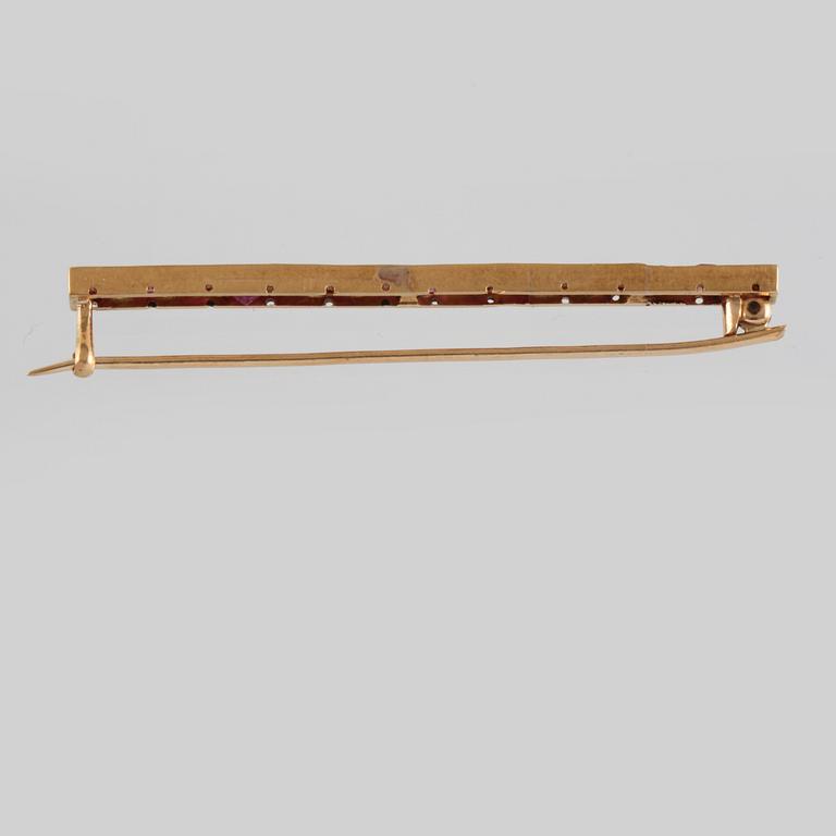 BROSCH, 18K guld med 15 fasettslipade rubiner. Vikt 4,8 gram.