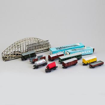 A set of Märklin electric trains, wagons,  rails, and a bridge.