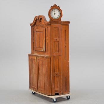 An 18th century cabinet with a clock.