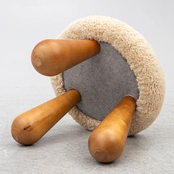 A contemporary stool with birch legs and new sheepskin upholstery.