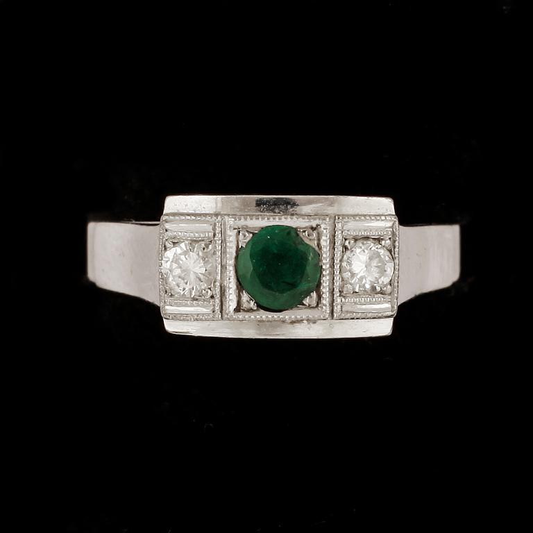 RING, 18k vitguld med briljantslipade diamanter tot ca0,15ct enl gravyr samt smaragd. Vikt 3,5g.