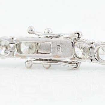 An 18K gold tennis bracelet with round brilliant-cut diamonds.