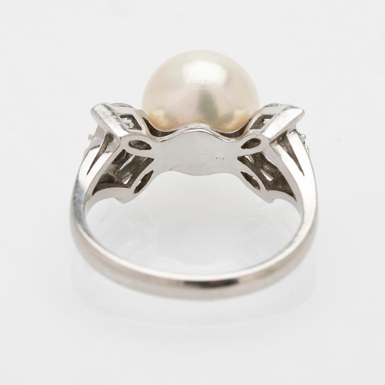 Platinum ring with a cultured pearl, emeralds and diamonds.