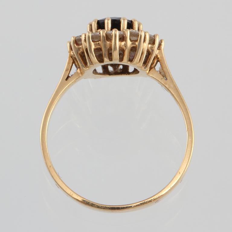 RING, 18K guld med ovalslipad blå safir samt 12 briljantslipade diamanter 0.73 ct, kattfotstämplad. Vikt 5,3 gram.