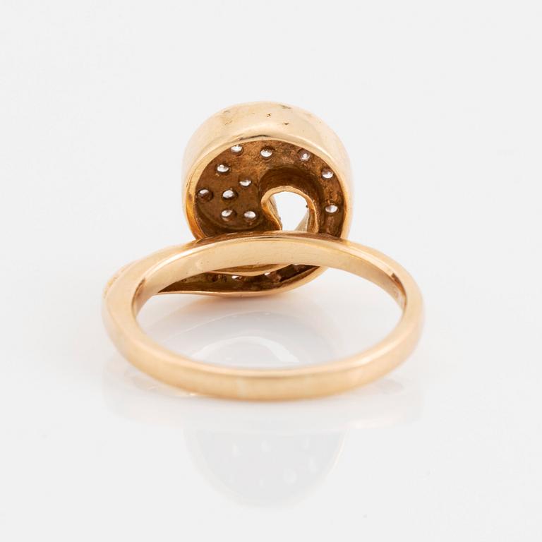 An 18K gold ring set with round brilliant-cut diamonds.