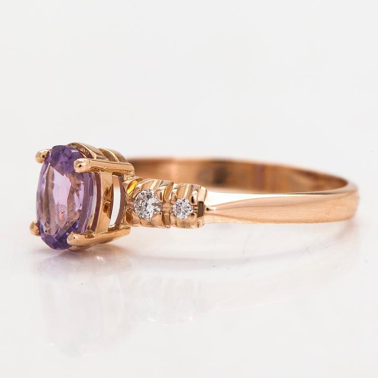 Ring, 14K guld, med en lila-rosa safir och diamanter tot. ca 0.07 ct. Kultakeskus, Tavastehus 1998.